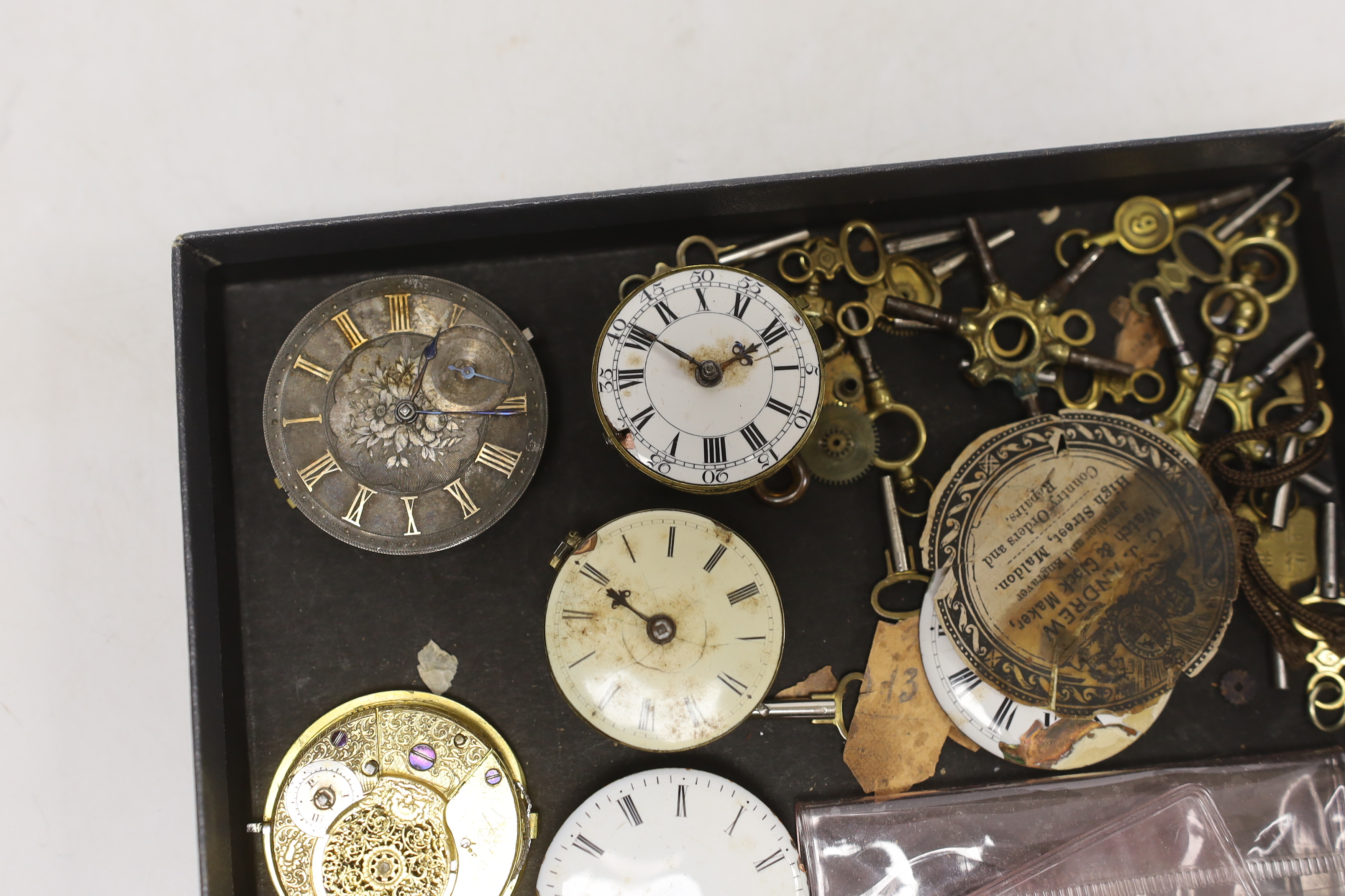 A small quantity of pocket watch accessories, including movements, dials and watch keys.